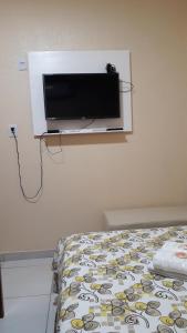 a bedroom with a tv on the wall and a bed at Pousada Restaurante Sol de Liz in Fortaleza