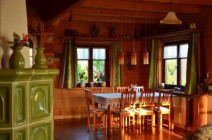 una sala da pranzo con tavolo, sedie e finestre di Góralska Ostoja a Pcim