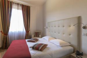 una camera da letto con un grande letto bianco con due cuscini di Hotel Settentrionale Esplanade a Montecatini Terme