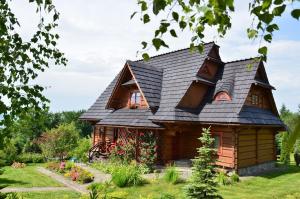 una baita di tronchi con tetto nero di Góralska Ostoja a Pcim