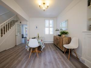 a dining room with a table and white chairs at Dunestal Cottage in Dartmouth