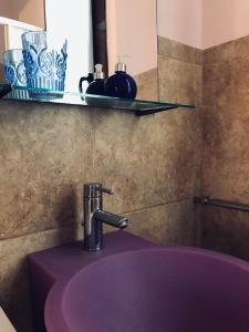 a sink in a bathroom with a purple sink at Sicilia Vacation rooms in Trapani