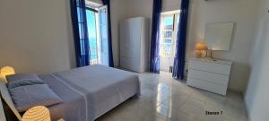 a bedroom with a bed and a dresser and windows at La casa sul mare in Lipari