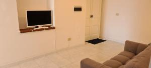a living room with a couch and a tv on a wall at La casa sul mare in Lipari