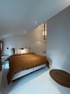 um quarto com uma cama num quarto branco em L'Officine - Résidence Le Cercle em Marche-en-Famenne
