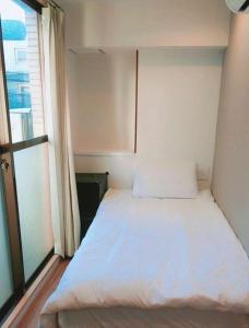 Rúm í herbergi á Tokyo shinjukutei Hotel Asahi gruop 東京新宿亭ホテル