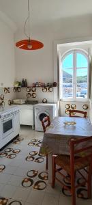 a kitchen with a table and a stove and a window at La casa sul mare in Lipari
