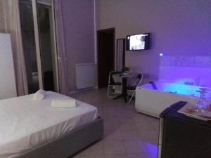 a bedroom with a bed and a tub with a tv at Vida Rooms Luxury in Palermo