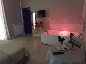 Habitación con bañera rosa, mesa y cama en Vida Rooms Luxury, en Palermo