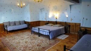 ein Schlafzimmer mit einem Bett und einem Sofa darin in der Unterkunft Le Manoir in Tarare