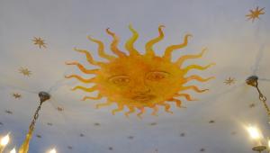 eine Zeichnung einer Sonne an einer Decke mit Lichtern in der Unterkunft Le Manoir in Tarare