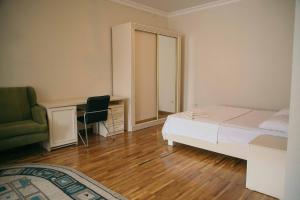 a bedroom with a bed and a desk and a chair at Hotel Lux in Makhachkala