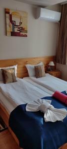 a bedroom with two beds and a blue blanket at Guest House Edelweiss in Govedartsi