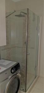 a washing machine in a bathroom with a shower at Ocean Breeze 23 in Kingsburgh