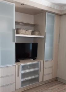 a living room with a tv in a closet at Ocean Breeze 23 in Kingsburgh