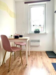 a dining room with a table and chairs and a window at Apartamencik Centrum in Polanica-Zdrój