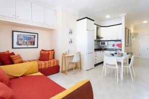 sala de estar y cocina con sofá y mesa en Home2Book Beach Front Las Gaviotas, en Santa Cruz de Tenerife