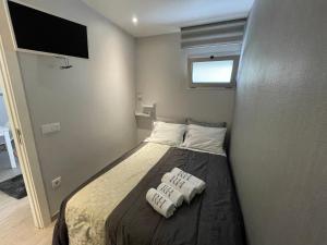 a small bedroom with a bed with two pillows on it at Rosa House in Nazaré