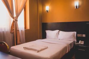 1 dormitorio con 1 cama con 2 toallas en Panone Hotel Mererani, en Mbuguni