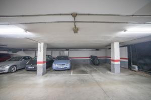 a parking garage with three cars parked in it at Apartment IFEMA-Mar de Cristal II in Madrid
