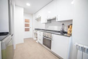 馬德里的住宿－Apartment IFEMA-Mar de Cristal II，厨房配有白色橱柜和炉灶。