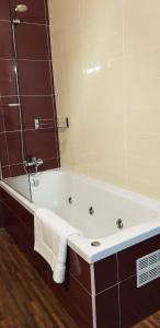a bathroom with a bath tub with a mirror at LA CASA DE HERACLES CADIZ in Cádiz