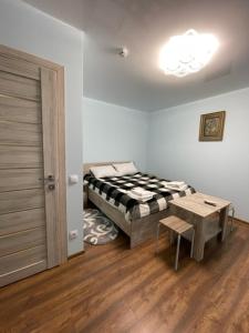 um quarto com uma cama, uma mesa e uma porta em Готель ТІК Копичинці em Sukhostav