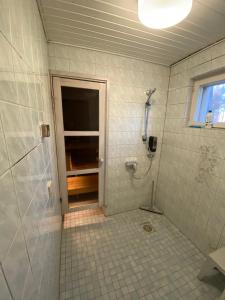 a tiled bathroom with a shower and a window at Hotel Aakenus Holiday Home Santa in Rovaniemi