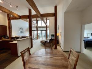kuchnia i salon z drewnianym stołem i krzesłami w obiekcie Luxurious Top Floor Villa With Sweeping Pacific Ocean - Bbv w mieście Ucluelet