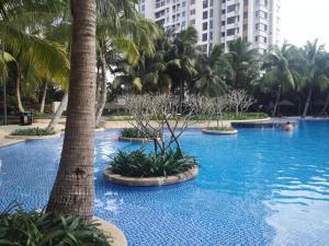 una grande piscina con palme e edifici di Guanlan Pavilion Seaview Homestay a Wenchang