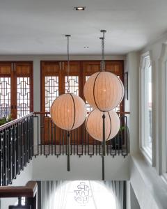 two lights hanging from a staircase in a house at The Lantern Hatyai Hotel in Hat Yai
