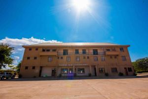 a large building with the sun in the sky at Panone Hotel Mererani in Mbuguni