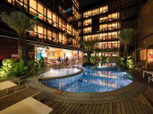 a building with a large pool in the middle of it at Ibis Styles Singapore On Macpherson in Singapore