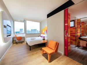 新加坡Ibis Styles Singapore On Macpherson的一间卧室，配有一张床、一张桌子和一把椅子 更多37张照片