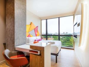 新加坡Ibis Styles Singapore On Macpherson的一间带床、书桌和窗户的酒店房间