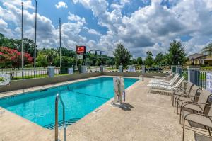 einen Pool in einem Resort mit Stühlen in der Unterkunft Econo Lodge in Goose Creek