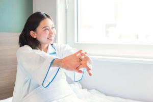 a woman in a white lab coat with a stethoscope at Comfort Hotel Toyama in Toyama