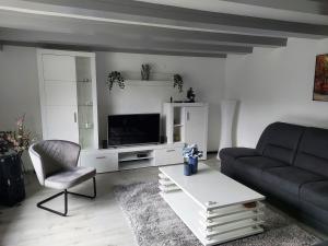 een woonkamer met een bank en een tv bij Familyhome Lopora in Medebach