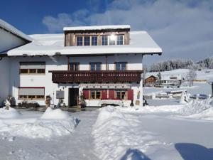 a house in the snow with a lot of snow around it at Ferienwohnung Linder in Hopferau