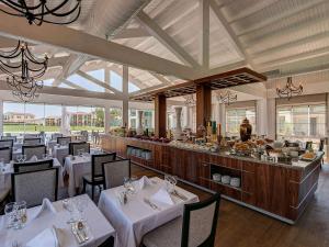 a restaurant with white tables and chairs and a buffet at Rixos Premium Tekirova - The Land of Legends Access in Tekirova