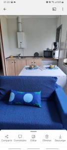 eine blaue Couch in einer Küche mit einem Tisch in der Unterkunft Apartamento en San Juan de L'arena in San Juan de la Arena