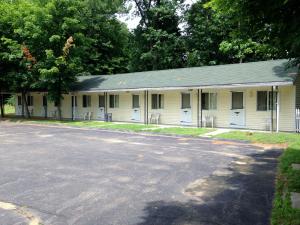 a building with white doors and a parking lot at Elmwood Motor Lodge in Boscawen