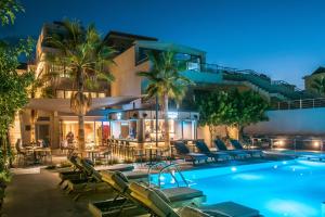 einen Pool mit Liegestühlen und ein Hotel in der Unterkunft Riviera Boutique Hotel in Stalida
