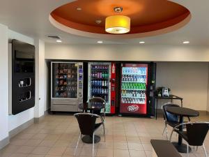 um restaurante com duas máquinas de refrigerante e cadeiras em Baymont by Wyndham Williston em Williston