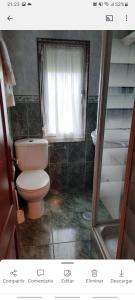 a bathroom with a toilet and a window at Apartamento en San Juan de L'arena in San Juan de la Arena