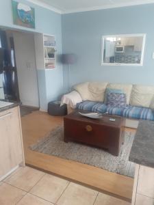 a living room with a couch and a coffee table at Vincentia Odd Cottage ( self catering) in East London