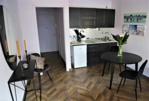 a kitchen with black cabinets and a table and chairs at Eden Residence in Cannes