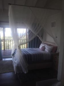 una camera con letto a baldacchino di Chilled Vibes a Ponta Mamoli