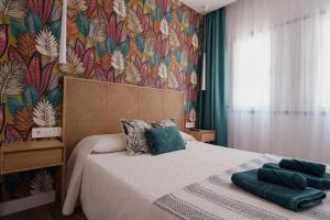 a bedroom with a bed with a floral wallpaper at La Pardela Excellence Apartamentos in Caleta de Sebo