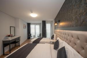 a hotel room with two beds and a desk at KA Hotel & Suites in Istanbul